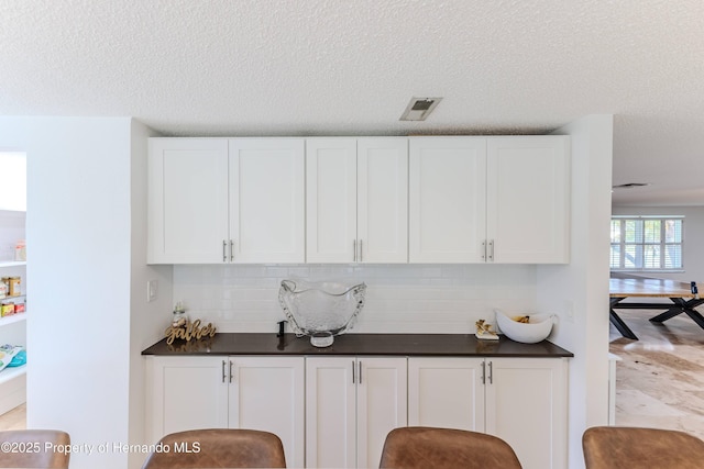 4566 Gulfstream Dr, Hernando Beach, FL 34607 - bar with a textured ceiling and tasteful backsplash