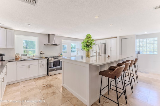 4566 Gulfstream Dr, Hernando Beach, FL 34607 - kitchen featuring appliances with stainless steel finishes, wall chimney exhaust hood, a sink, plenty of natural light, and a textured ceiling