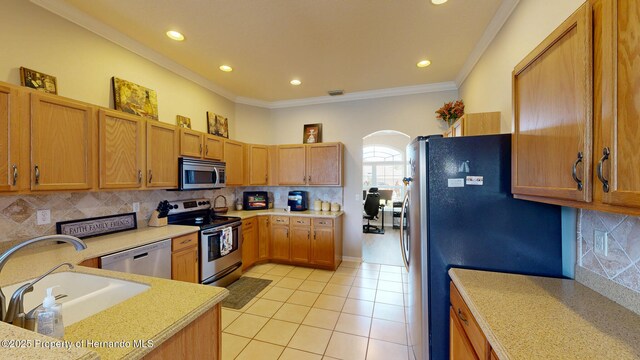 22316 Red Jacket, Land O Lakes, FL 34639 - kitchen featuring appliances with stainless steel finishes, a sink, light tile patterned floors, light countertops, and crown molding