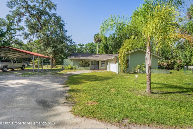 9766 W Smokey Ln, Crystal River, FL 34429 - view of front of property featuring a front lawn, dirt driveway, a carport, and stucco siding