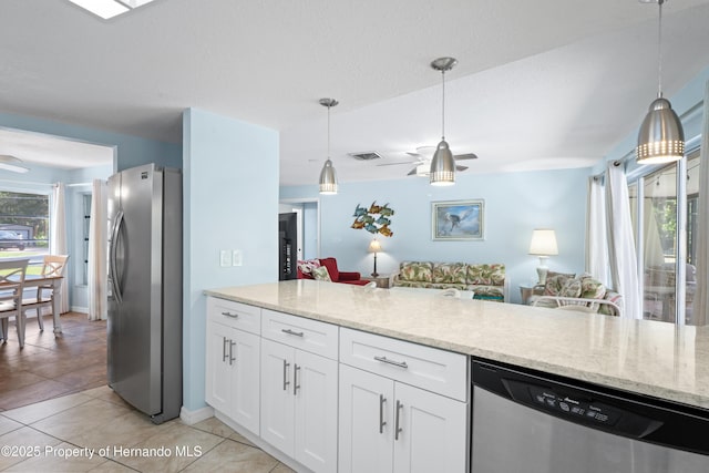 9766 W Smokey Ln, Crystal River, FL 34429 - kitchen with stainless steel appliances, open floor plan, white cabinetry, and light stone counters