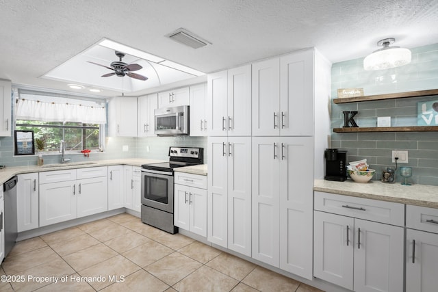 9766 W Smokey Ln, Crystal River, FL 34429 - kitchen featuring stainless steel appliances, tasteful backsplash, a ceiling fan, a sink, and a textured ceiling