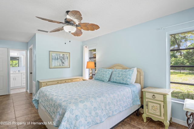 9766 W Smokey Ln, Crystal River, FL 34429 - bedroom featuring baseboards, tile patterned flooring, connected bathroom, and a ceiling fan