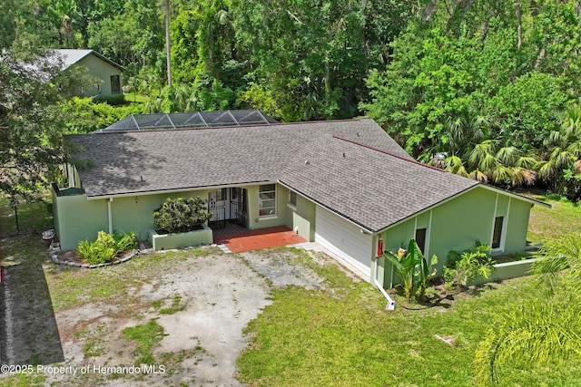 9766 W Smokey Ln, Crystal River, FL 34429 - ranch-style house featuring a shingled roof, dirt driveway, stucco siding, and a front yard
