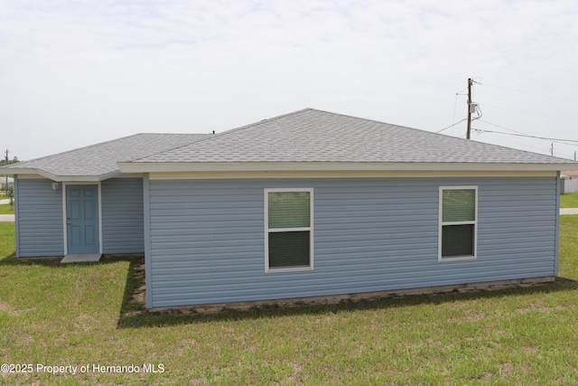 2001 W Royal Palm Dr, Dunnellon, FL 34434 - back of house featuring a shingled roof and a yard