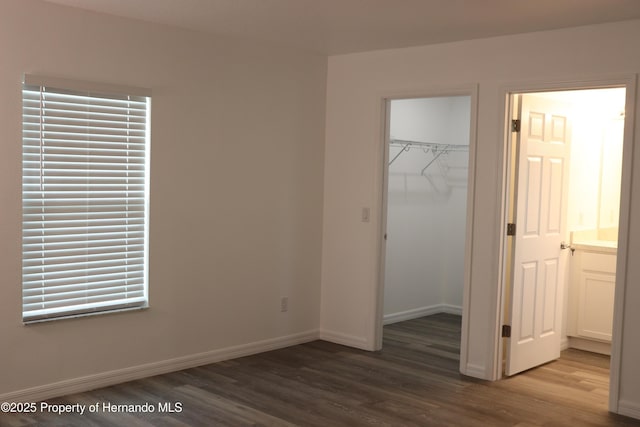 2001 W Royal Palm Dr, Dunnellon, FL 34434 - unfurnished bedroom with wood finished floors, a walk in closet, baseboards, and a closet