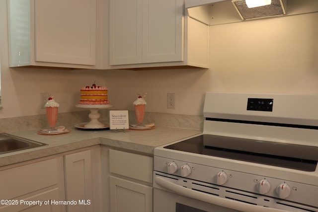 2001 W Royal Palm Dr, Dunnellon, FL 34434 - kitchen featuring electric stove, light countertops, range hood, and white cabinetry