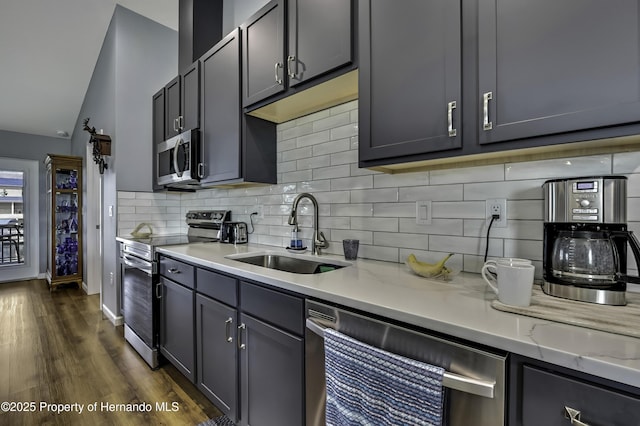 4123 Daisy Dr, Hernando Beach, FL 34607 - kitchen featuring stainless steel appliances, a sink, vaulted ceiling, backsplash, and dark wood-style floors