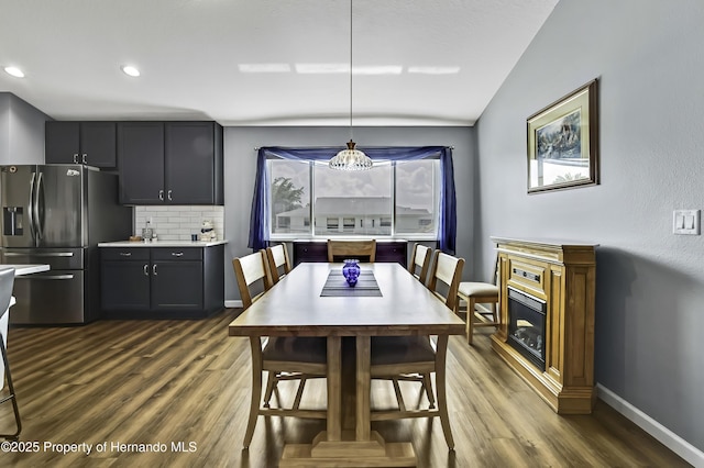 4123 Daisy Dr, Hernando Beach, FL 34607 - dining room with dark wood-style flooring, baseboards, recessed lighting, vaulted ceiling, and a fireplace