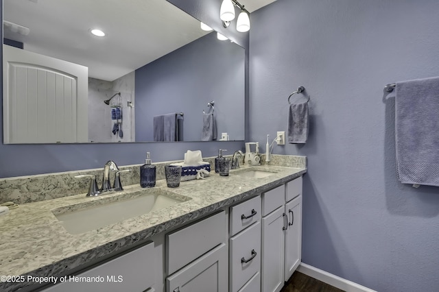 4123 Daisy Dr, Hernando Beach, FL 34607 - full bath with double vanity, baseboards, wood finished floors, and a shower