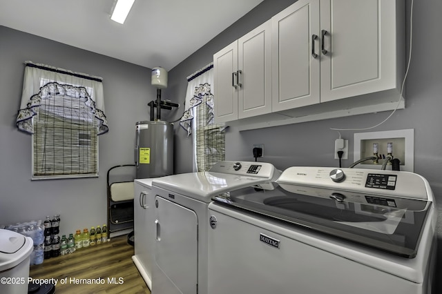 4123 Daisy Dr, Hernando Beach, FL 34607 - washroom with washing machine and dryer, cabinet space, electric water heater, and dark wood-style flooring