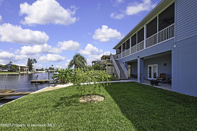 4123 Daisy Dr, Hernando Beach, FL 34607 - view of green lawn featuring a patio area, a water view, stairs, a sunroom, and french doors
