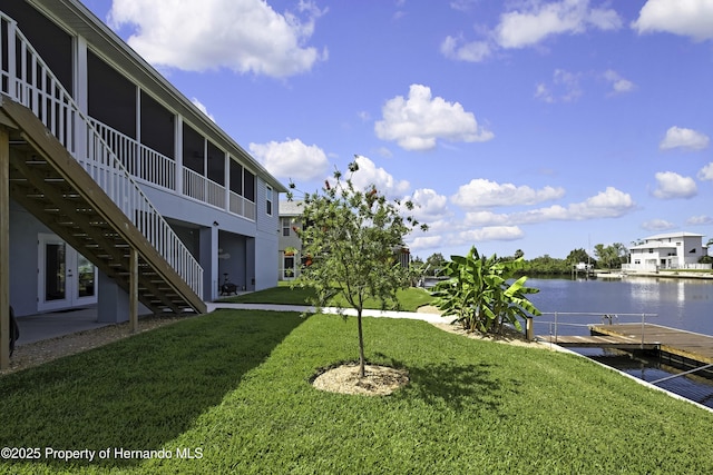 4123 Daisy Dr, Hernando Beach, FL 34607 - view of green lawn with a water view, a dock, stairs, and a sunroom
