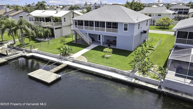 4123 Daisy Dr, Hernando Beach, FL 34607 - back of property featuring a sunroom, a patio area, a water view, roof with shingles, and a residential view