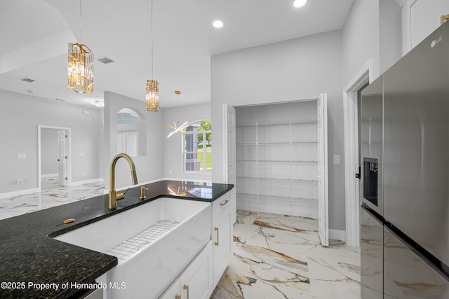 5317 Lydia Ct, Spring Hill, FL 34608 - kitchen featuring stainless steel fridge, light marble finish flooring, a sink, dark stone countertops, and white cabinetry