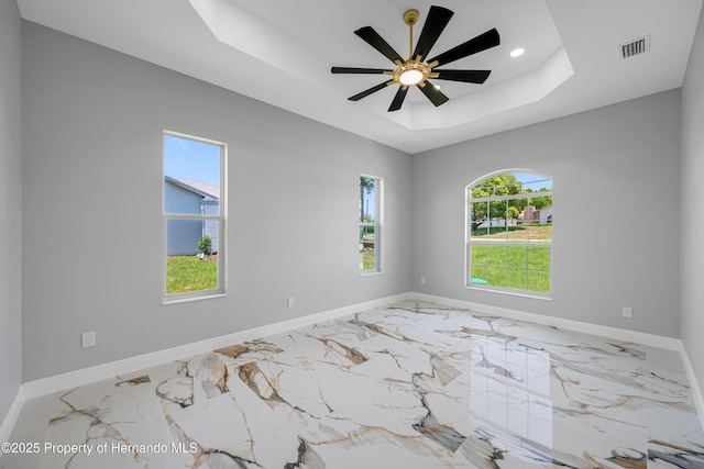 5317 Lydia Ct, Spring Hill, FL 34608 - empty room with a tray ceiling, plenty of natural light, baseboards, recessed lighting, and marble finish flooring