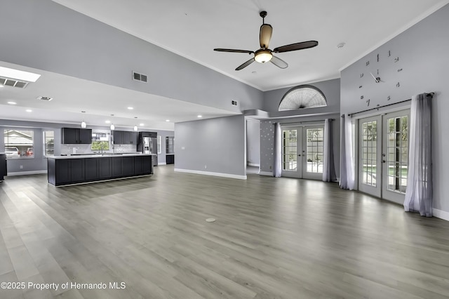 10277 Rosetti Ct, Spring Hill, FL 34608 - unfurnished living room with french doors, baseboards, ornamental molding, a towering ceiling, and a ceiling fan