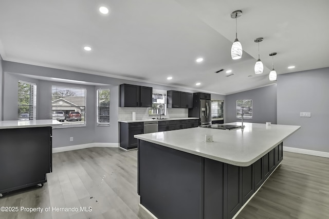 10277 Rosetti Ct, Spring Hill, FL 34608 - kitchen with light wood-type flooring, light countertops, appliances with stainless steel finishes, baseboards, and recessed lighting