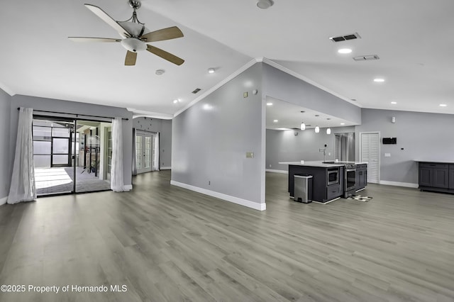10277 Rosetti Ct, Spring Hill, FL 34608 - unfurnished living room with crown molding, baseboards, vaulted ceiling, light wood-style flooring, and ceiling fan