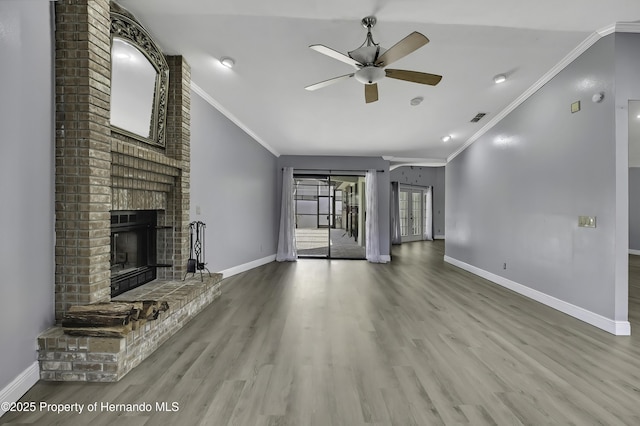 10277 Rosetti Ct, Spring Hill, FL 34608 - unfurnished living room with crown molding, a ceiling fan, vaulted ceiling, wood finished floors, and a brick fireplace