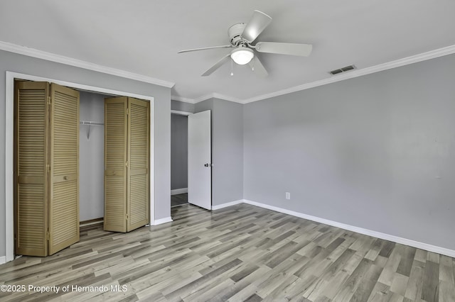 10277 Rosetti Ct, Spring Hill, FL 34608 - unfurnished bedroom featuring wood finished floors, a closet, baseboards, crown molding, and a ceiling fan
