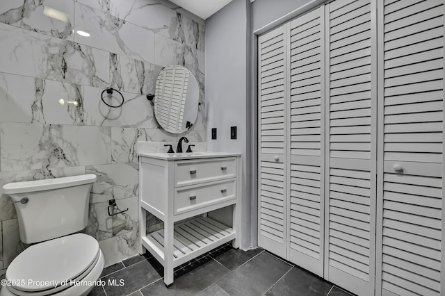 10277 Rosetti Ct, Spring Hill, FL 34608 - bathroom with vanity, toilet, tile walls, and a closet