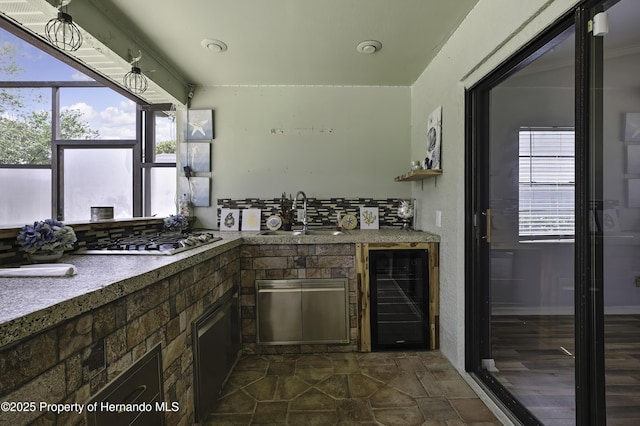 10277 Rosetti Ct, Spring Hill, FL 34608 - kitchen with wine cooler, stainless steel gas cooktop, a sink, decorative backsplash, and dark stone finish flooring