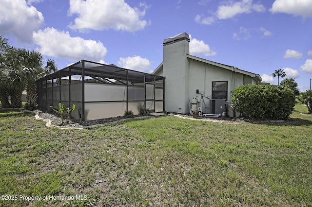 10277 Rosetti Ct, Spring Hill, FL 34608 - rear view of property with a yard, a chimney, stucco siding, and a lanai