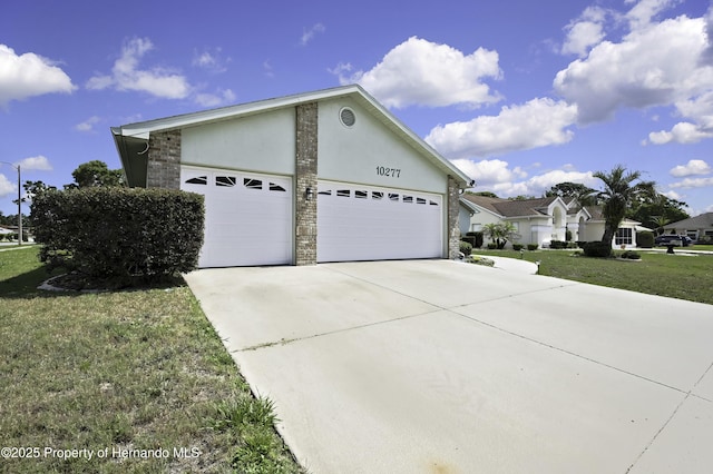 10277 Rosetti Ct, Spring Hill, FL 34608 - view of side of home featuring driveway, a garage, stucco siding, a lawn, and stone siding