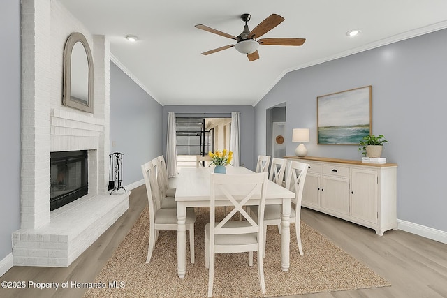 10277 Rosetti Ct, Spring Hill, FL 34608 - dining area with crown molding, light wood finished floors, ceiling fan, vaulted ceiling, and a brick fireplace