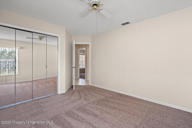 13491 Coronado Dr, Spring Hill, FL 34609 - unfurnished bedroom featuring a textured ceiling, carpet floors, a closet, baseboards, and ceiling fan