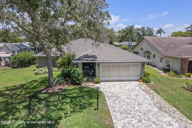 2486 Deer Trail Ln, Spring Hill, FL 34606 - view of front facade featuring a garage, decorative driveway, a front yard, brick siding, and central AC