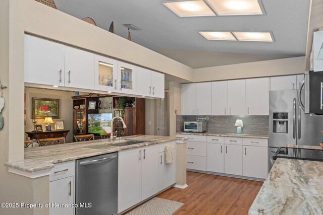 2486 Deer Trail Ln, Spring Hill, FL 34606 - kitchen featuring appliances with stainless steel finishes, a sink, light wood-type flooring, tasteful backsplash, and white cabinetry