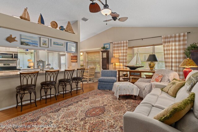 2486 Deer Trail Ln, Spring Hill, FL 34606 - living room featuring lofted ceiling, wood finished floors, ceiling fan, and a textured ceiling