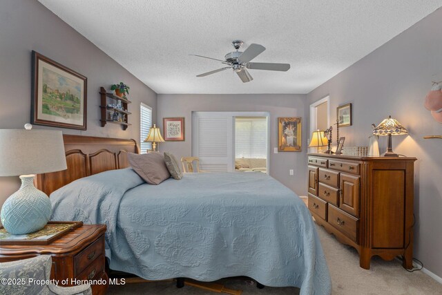 2486 Deer Trail Ln, Spring Hill, FL 34606 - bedroom with light colored carpet, a textured ceiling, and a ceiling fan