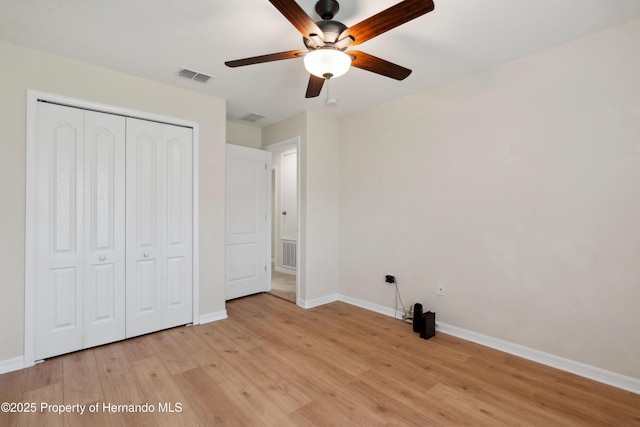 18710 Dobson Dr, Hudson, FL 34667 - unfurnished bedroom with a closet, baseboards, light wood-style flooring, and a ceiling fan