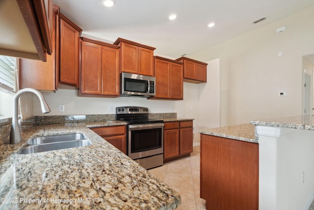 18710 Dobson Dr, Hudson, FL 34667 - kitchen featuring appliances with stainless steel finishes, a sink, brown cabinets, recessed lighting, and light stone countertops