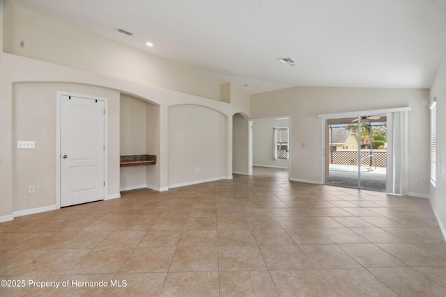 18710 Dobson Dr, Hudson, FL 34667 - unfurnished room with lofted ceiling, light tile patterned floors, baseboards, recessed lighting, and arched walkways