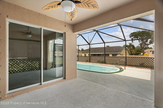 18710 Dobson Dr, Hudson, FL 34667 - outdoor pool featuring ceiling fan, a patio, and glass enclosure