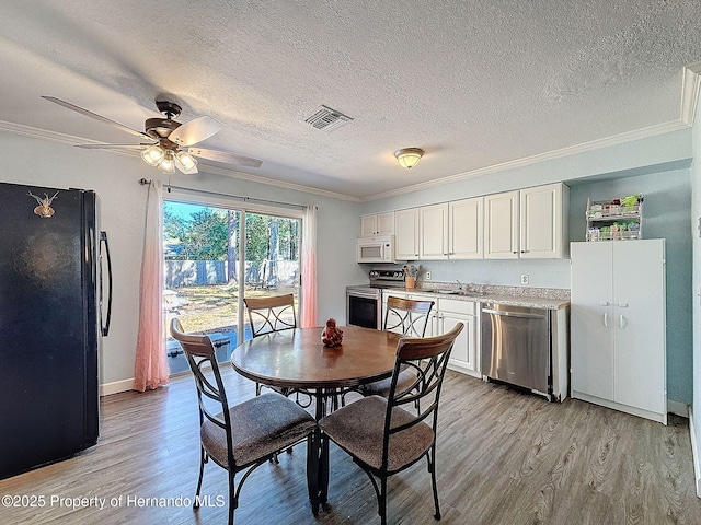 1531 NE 38th St, Ocala, FL 34479 - dining area featuring crown molding, a textured ceiling, light wood-style flooring, ceiling fan, and baseboards