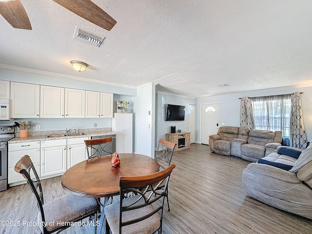1531 NE 38th St, Ocala, FL 34479 - dining room featuring a textured ceiling, light wood-style flooring, and ornamental molding