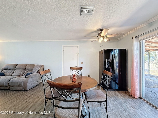 1531 NE 38th St, Ocala, FL 34479 - dining area featuring light wood-style floors, ceiling fan, crown molding, a textured ceiling, and baseboards