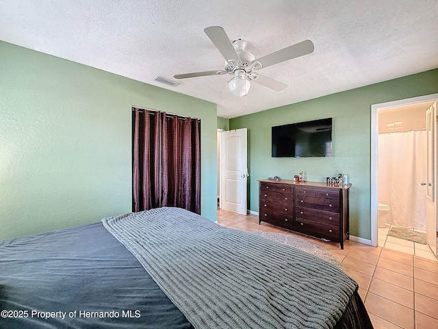 1531 NE 38th St, Ocala, FL 34479 - bedroom featuring light tile patterned flooring, ceiling fan, a textured ceiling, baseboards, and ensuite bathroom