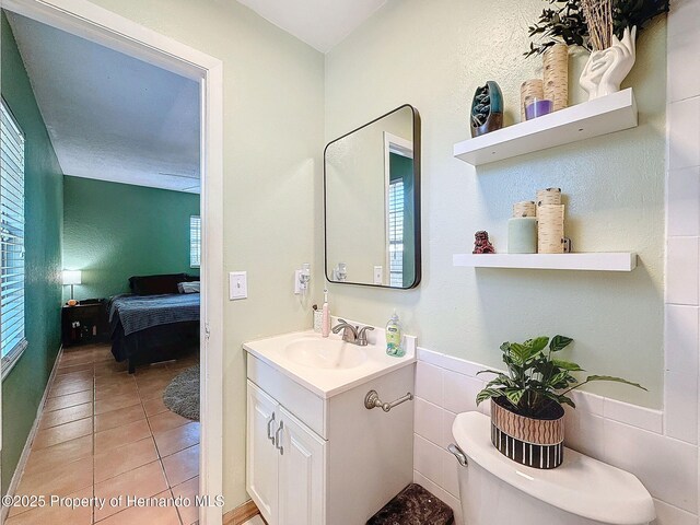 1531 NE 38th St, Ocala, FL 34479 - bathroom featuring vanity, tile patterned floors, ensuite bathroom, toilet, and tile walls