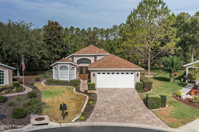 11404 Inman Ct, Spring Hill, FL 34609 - view of front of home featuring stucco siding, a garage, a front lawn, driveway, and a shingled roof