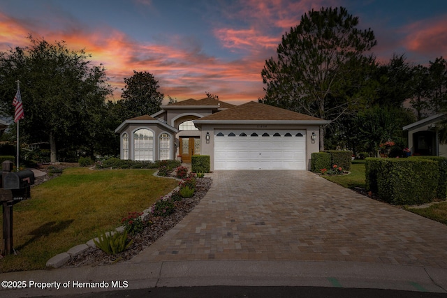 11404 Inman Ct, Spring Hill, FL 34609 - view of front of property featuring a yard, decorative driveway, a garage, and stucco siding