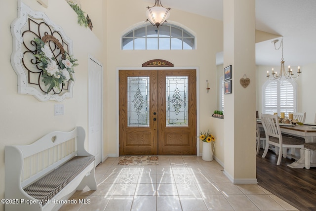 11404 Inman Ct, Spring Hill, FL 34609 - entryway with a chandelier, a high ceiling, baseboards, light tile patterned floors, and french doors