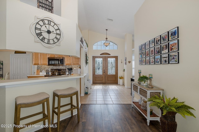 11404 Inman Ct, Spring Hill, FL 34609 - foyer with high vaulted ceiling and dark wood-style flooring