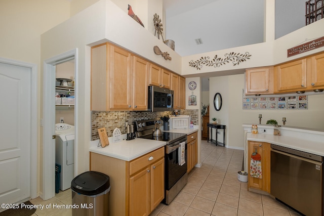 11404 Inman Ct, Spring Hill, FL 34609 - kitchen featuring stainless steel appliances, washer / clothes dryer, a high ceiling, tasteful backsplash, and light countertops