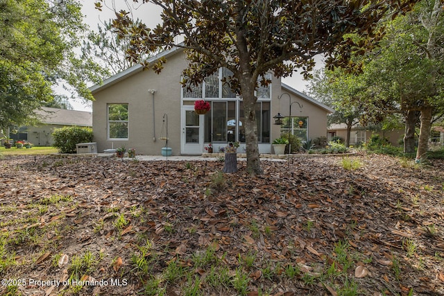 11404 Inman Ct, Spring Hill, FL 34609 - rear view of property featuring stucco siding and a sunroom